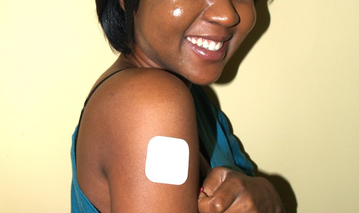 A photo of a young Black women revealing an Evra Patch on her right shoulder.